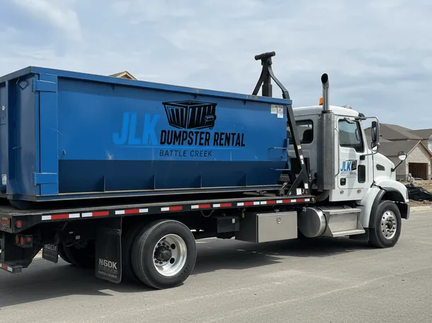 Our dumpster rental process in Battle Creek Roll-off container being set on a Battle Creek, MI property